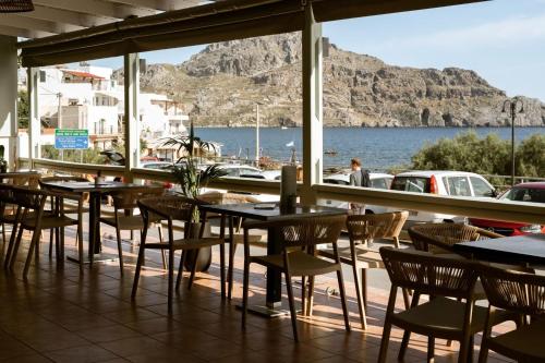 ein Restaurant mit Tischen und Stühlen und Blick auf das Wasser in der Unterkunft Endless Blue Seaside View in Plakias