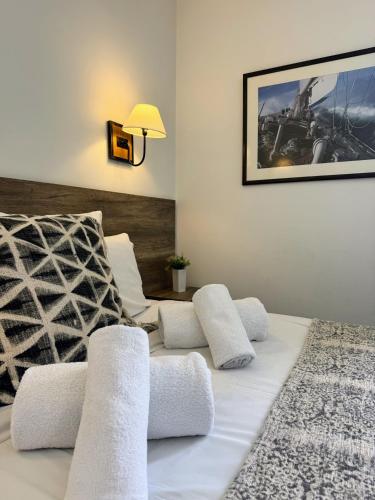 - un lit blanc avec des oreillers blancs et une lampe dans l'établissement Antibes Port - Terrasse - Parking - Piscine, à Antibes