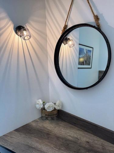 une salle de bain avec un miroir et un panier de fleurs dans l'établissement Antibes Port - Terrasse - Parking - Piscine, à Antibes