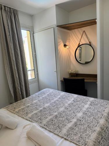 une chambre avec un lit, un miroir et une fenêtre dans l'établissement Antibes Port - Terrasse - Parking - Piscine, à Antibes