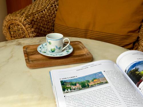 a coffee cup and a book on a table with a book at BELLE ILE PARK in Griante Cadenabbia