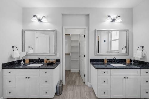 a bathroom with two sinks and two mirrors at Regal Island Retreat in Flour Bluff