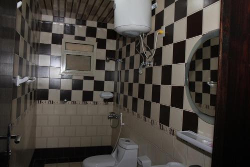 a bathroom with a toilet and a sink and a mirror at أمواج للشقق المخدومة - FoR SERVICED APARTMENTS in Al Jubail