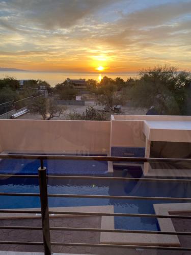 a sunset over a swimming pool on top of a building at STELLA MARIS Boutique Hotel in El Sargento