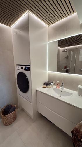 a white bathroom with a sink and a mirror at Panoramic views in Henningsvær in Henningsvær