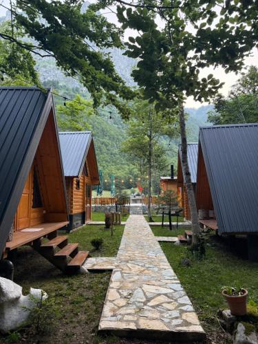 a row of cottages with a pathway in the grass at WildBeauty Grebaje in Vusanje