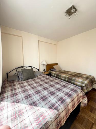 a bedroom with two beds in a room at Departamento soleado y acogedor en el mejor barrio de la ciudad in La Paz