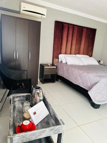 a hotel room with a bed and a table with a table at Rose's Lodge in Ga-Selala