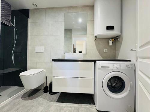 une salle de bain avec machine à laver et toilettes dans l'établissement Le Moga - WIFI - TV, à Bègles