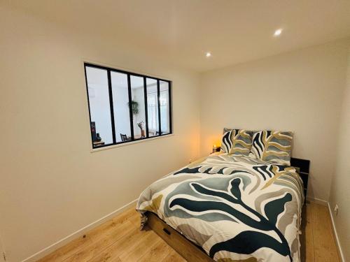 une chambre avec un grand lit avec une fenêtre dans l'établissement Le Moga - WIFI - TV, à Bègles