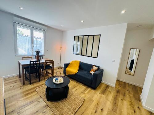 un salon avec un canapé et une table dans l'établissement Le Moga - WIFI - TV, à Bègles