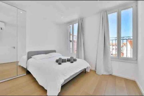 une chambre blanche avec un lit et une grande fenêtre dans l'établissement Beautiful 2-room apartment on the Croisette in Cannes, à Cannes