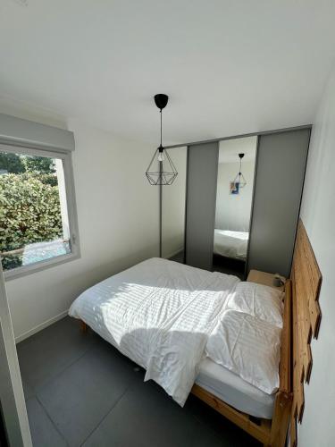 une chambre avec un lit et une fenêtre dans l'établissement Modern garden apartment, à Labenne