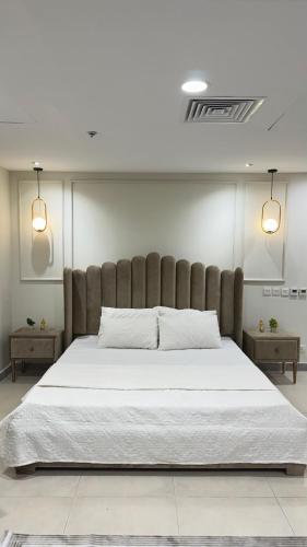 un letto grande in una stanza con due tavoli di Cozy Studio Apartment a Lahore