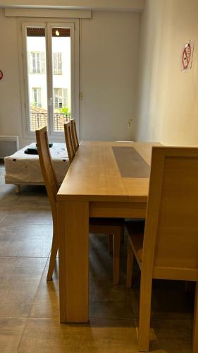 - une table et des chaises en bois dans l'établissement One bedroom near train station, à Nice