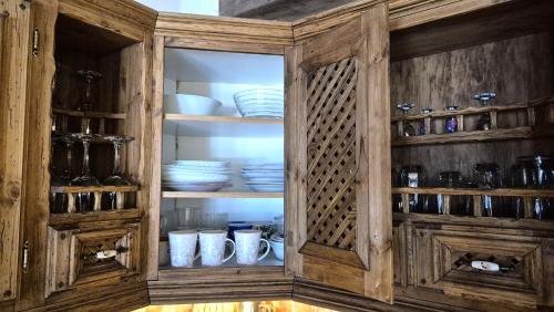 a wooden cabinet with plates and dishes in it at Deluxe Apartments in the city center with Balcony in Pärnu