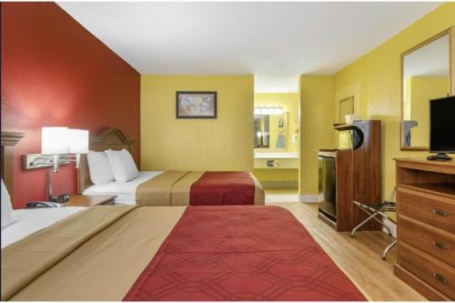 a hotel room with two beds and a flat screen tv at Travelers Inn Douglas By OYO US-441 in Douglas