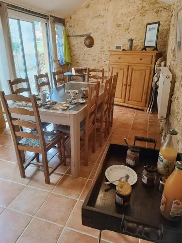 une cuisine avec une table et des chaises dans une pièce dans l'établissement Villa EsquirHall, chambres d'hôtes, à Journiac