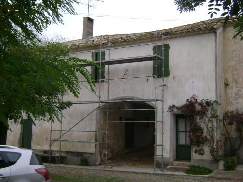 un bâtiment blanc avec une porte et un garage dans l'établissement Domaine de Curatiès, à Quarante