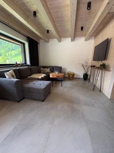 a living room with a couch and a flat screen tv at Happynewhome Slovenský Raj in Hnilčík