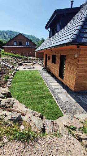 a building with a yard next to a house at Happynewhome Slovenský Raj in Hnilčík