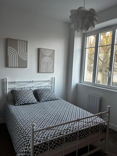 - une chambre dotée d'un lit avec des draps noirs et blancs dans l'établissement Salon lumineux, à La Celle-sous-Gouzon