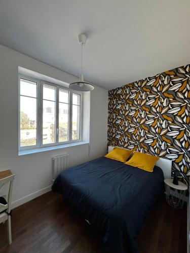 - une chambre dotée d'un lit avec un mur coloré dans l'établissement Salon lumineux, à La Celle-sous-Gouzon