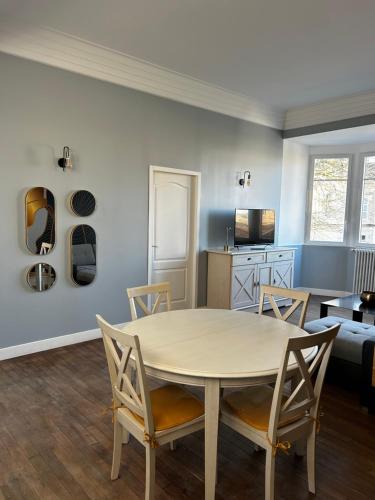 une salle à manger et un salon avec une table et des chaises dans l'établissement Salon lumineux, à La Celle-sous-Gouzon