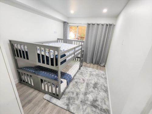 a bedroom with two bunk beds and a window at Gorgeous Two Bedroom Suite in a Quiet, Picturesque Neighborhood! in West Vancouver