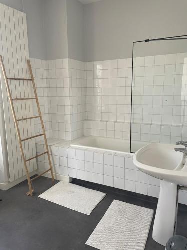 une salle de bain avec une baignoire, un lavabo et un miroir dans l'établissement Pretty house with garden near Reims Champagne, à Cormontreuil