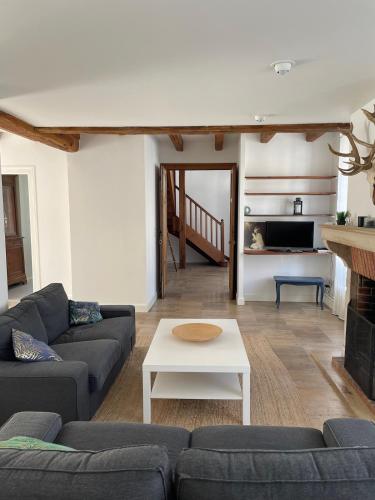 un salon avec un canapé et une table dans l'établissement Pretty house with garden near Reims Champagne, à Cormontreuil