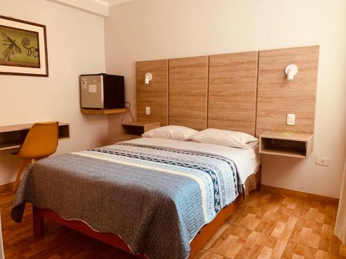 a bedroom with a large bed and a tv at Silpay in Tacna