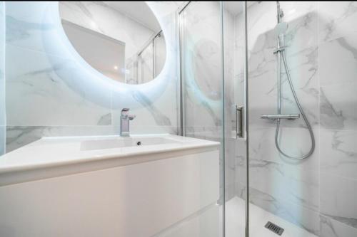 une salle de bain blanche avec un lavabo et une douche dans l'établissement Cannes Croisette T2 new sublime, à Cannes