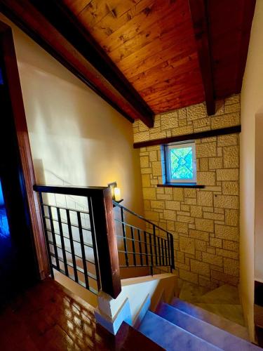 a staircase in a building with a stone wall and a window at Harmony Home in Pýrgos
