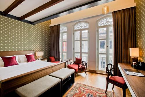 una camera d'albergo con letto e scrivania di The Sultan a Singapore