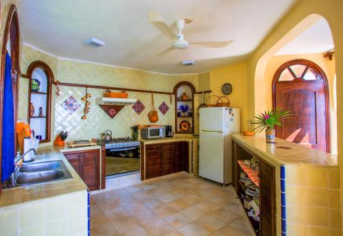 a kitchen with a white refrigerator and a sink at Casa de La Paz - Beautiful Beachfront Villa in Puerto Escondido