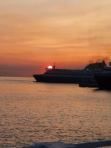 a large cruise ship in the water at sunset at ELLI TROPiCAL LUXURY SUITES SUNSET-INFINITY POOL- SEA SIDE-NEAR CENTER PARKING in Mikonos