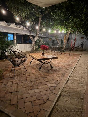 a patio with a table and chairs and lights at Casa Sixta a 7min del aeropuerto internacional PMX y 2 cuadras terminal autob ADO in Puerto Escondido