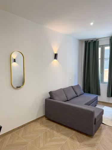 Una sala de estar con un sofá y un espejo. en T1 luxury Port Toulon Clim, Wi-Fi, en Toulon