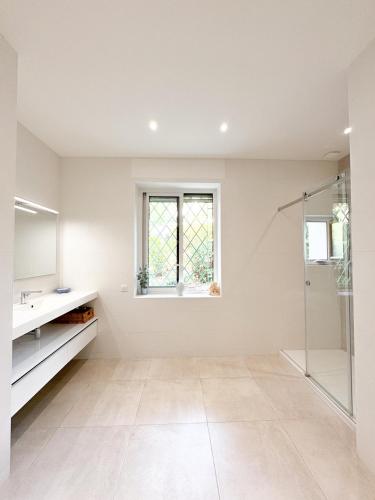 une salle de bain blanche avec une douche et un lavabo dans l'établissement Bestouan - 3 Chambres - Clim - Spacieux, à Cassis