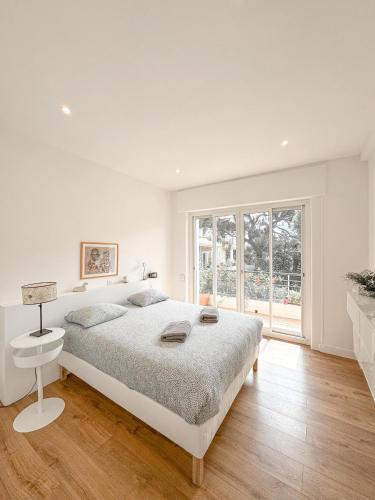une chambre blanche avec un lit et une fenêtre dans l'établissement Bestouan - 3 Chambres - Clim - Spacieux, à Cassis