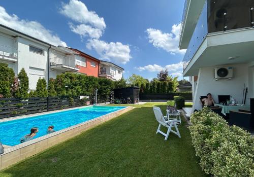 a swimming pool in the backyard of a house at TemOro Apartman Green in Siófok