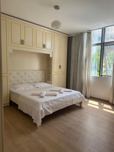 ein Schlafzimmer mit einem großen Bett, auf dem Handtücher liegen in der Unterkunft Prime Apartment in Tirana