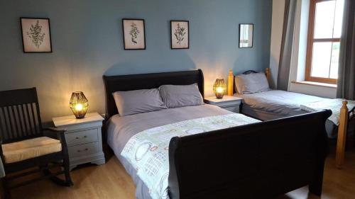a bedroom with two beds and a chair and two lamps at Murphy's Irish farmhouse near Ballybunion in Ballybunion