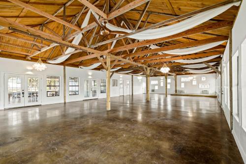 an empty room with wooden ceilings and a large room with a concrete floor at The Claire Hotel in Canyon Lake