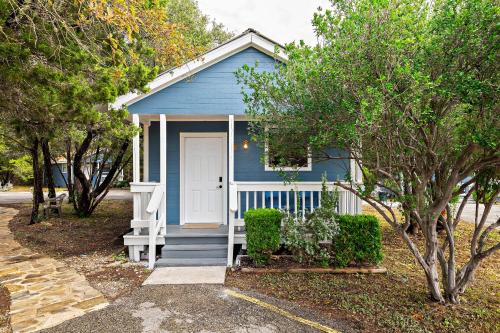 a blue house with a white door and trees at The Claire Hotel in Canyon Lake