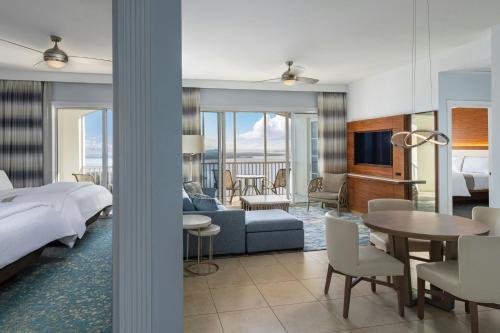ein Hotelzimmer mit einem Bett und einem Wohnzimmer in der Unterkunft The Westin Cape Coral Resort at Marina Village in Cape Coral
