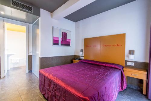 um quarto com uma cama grande e uma colcha roxa em Colors em Barcelona
