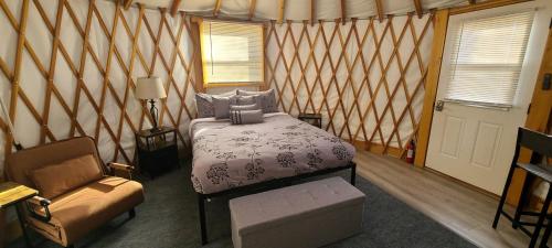 a bedroom with a bed and a couch and a chair at Crazy Horse - APT 1 in Kanab