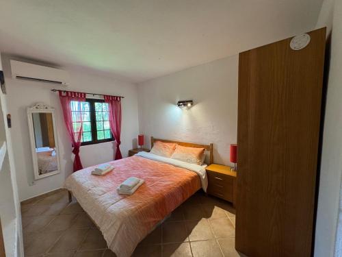 a bedroom with a bed with two towels on it at Vivenda Paloverde in Lagoa